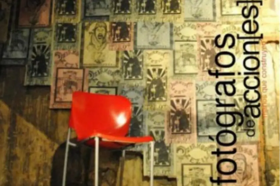 Una silla roja frente a unos afiches y la frase Fotógrafos de acciones