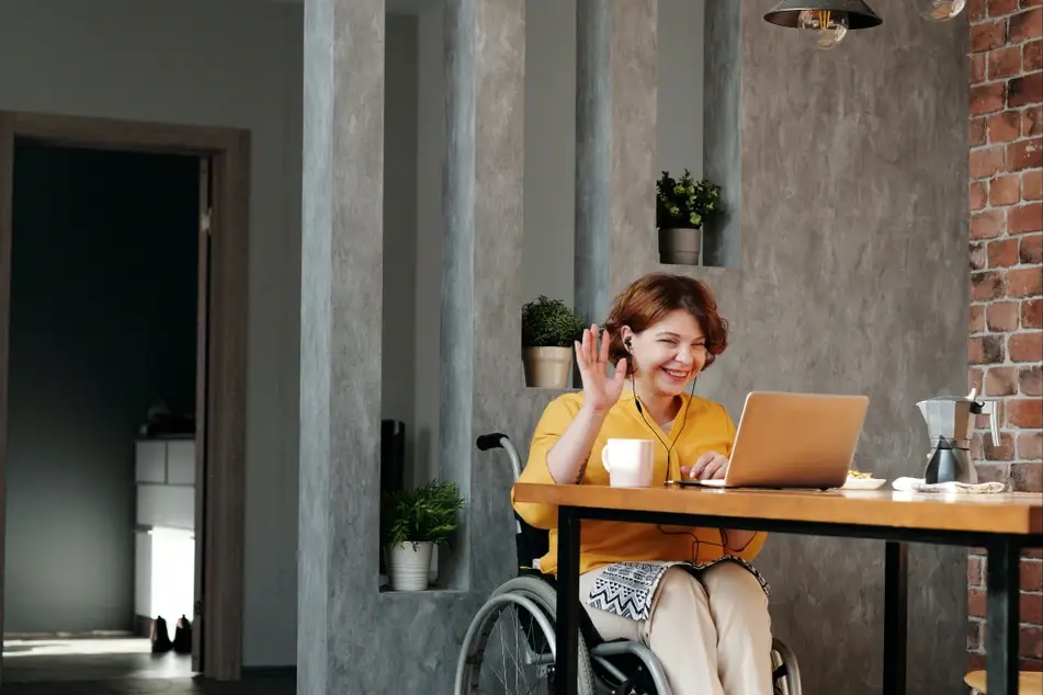 woman smiling and waving at laptop