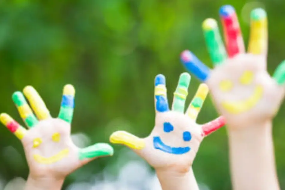 Manos de niños pintadas con colores vivos
