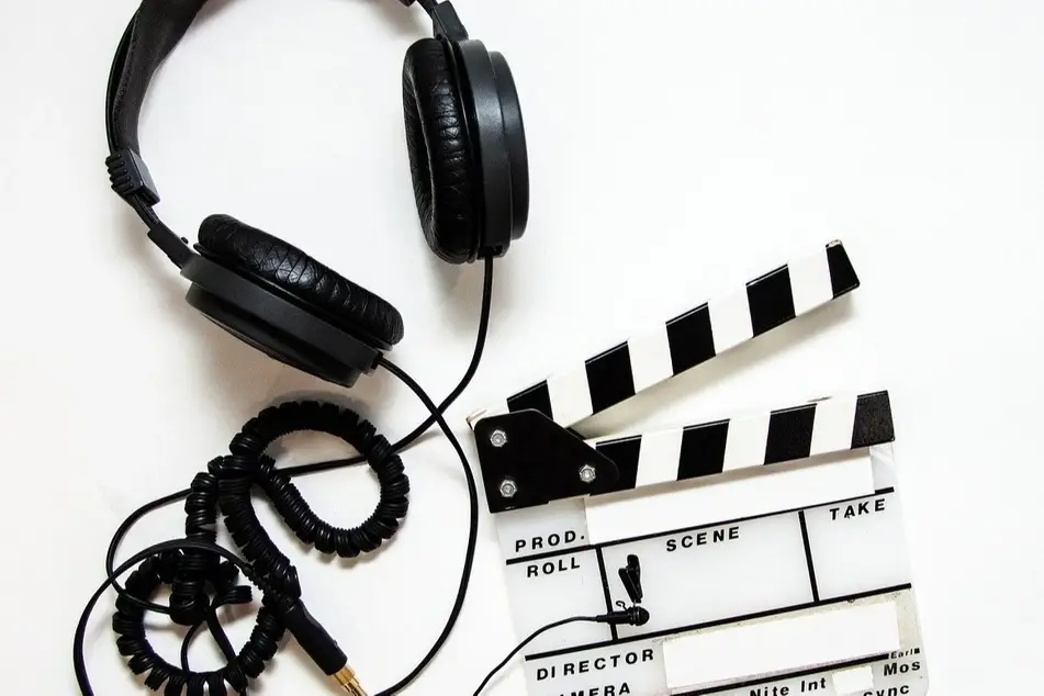 A pair of headphones over a film clapper.