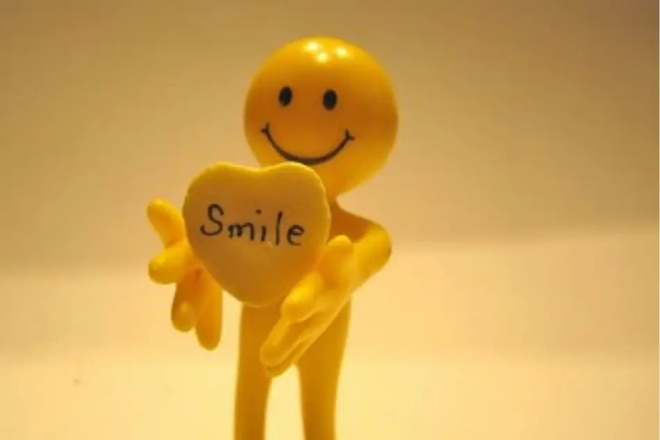 Un muñequito feliz con un corazón que dice Sonríe
