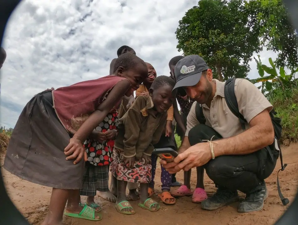 group of children with man looking at a phone