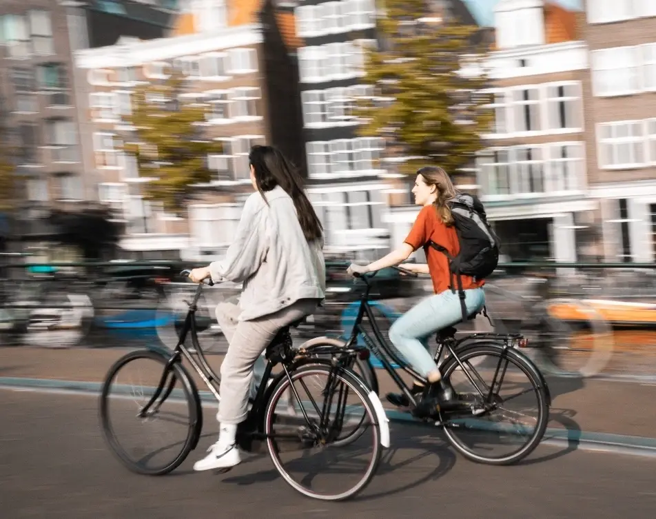 Dos mujeres montando bicicleta en un espacio urbano