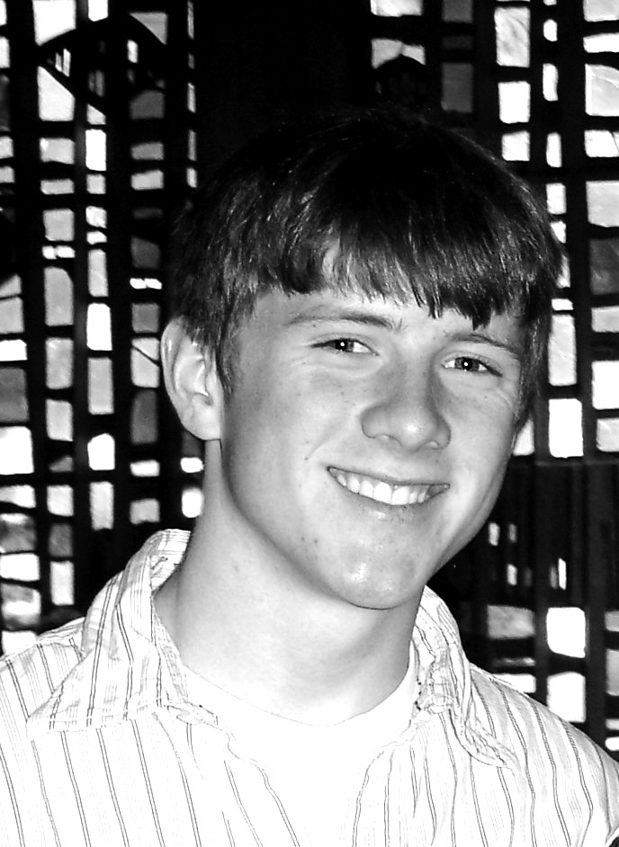 Young adult man with cut across bangs smiling at the camera