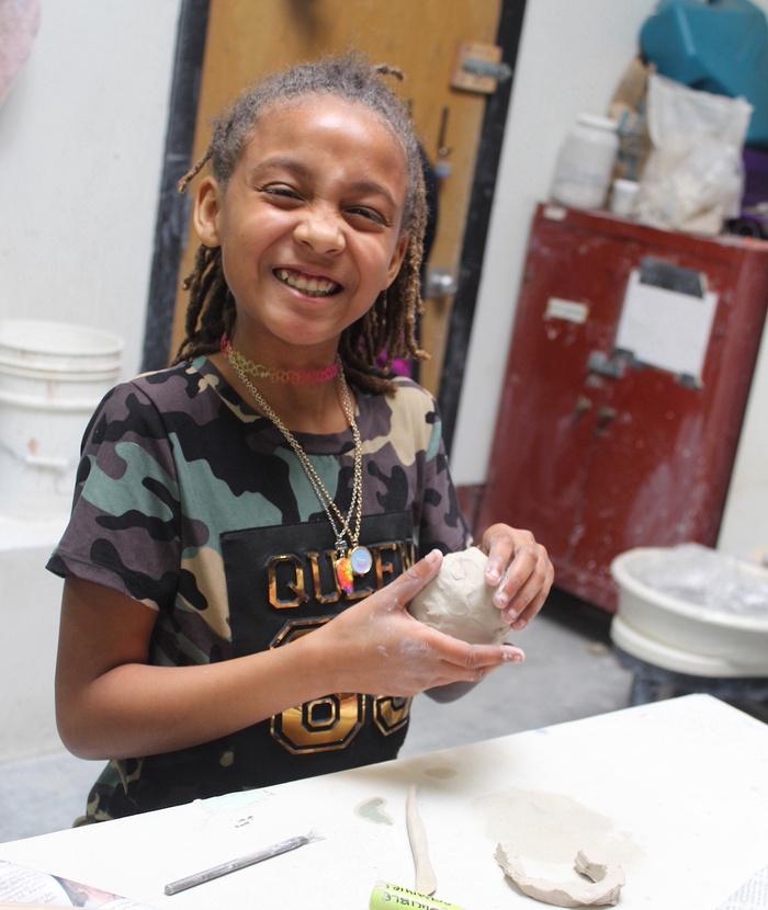A Crucible youth student shapes clay into a pinch pot during Youth Clay Critters