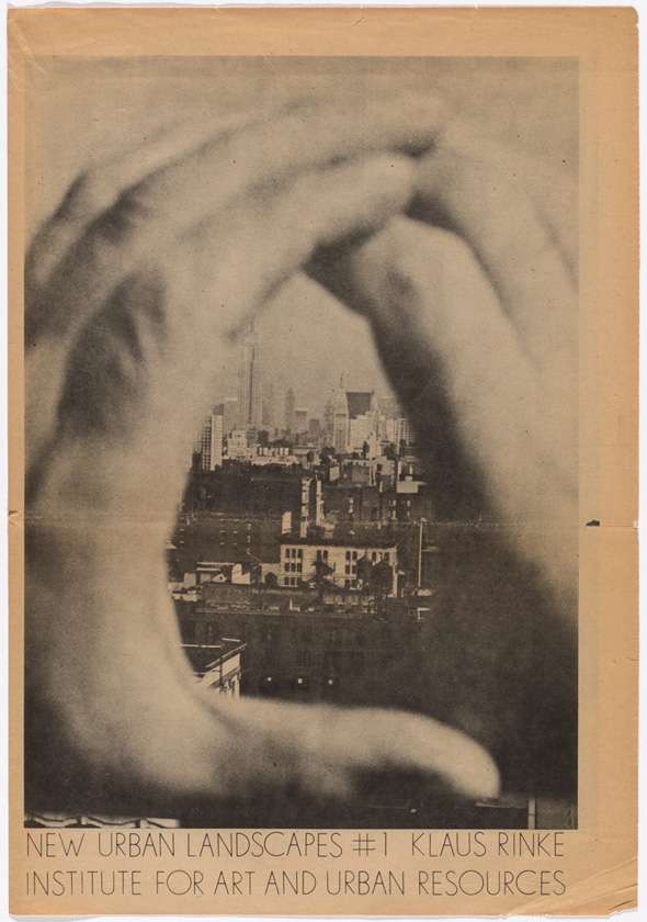 A black and white image printed on aged newsprint of soft-focused hands framing a view of New York City.  Printed below the image in light sans serif font reads “NEW URBAN LANDSCAPES #1 KLAUS RINKE INSTITUTE FOR ART AND URBAN RESOURCES”.