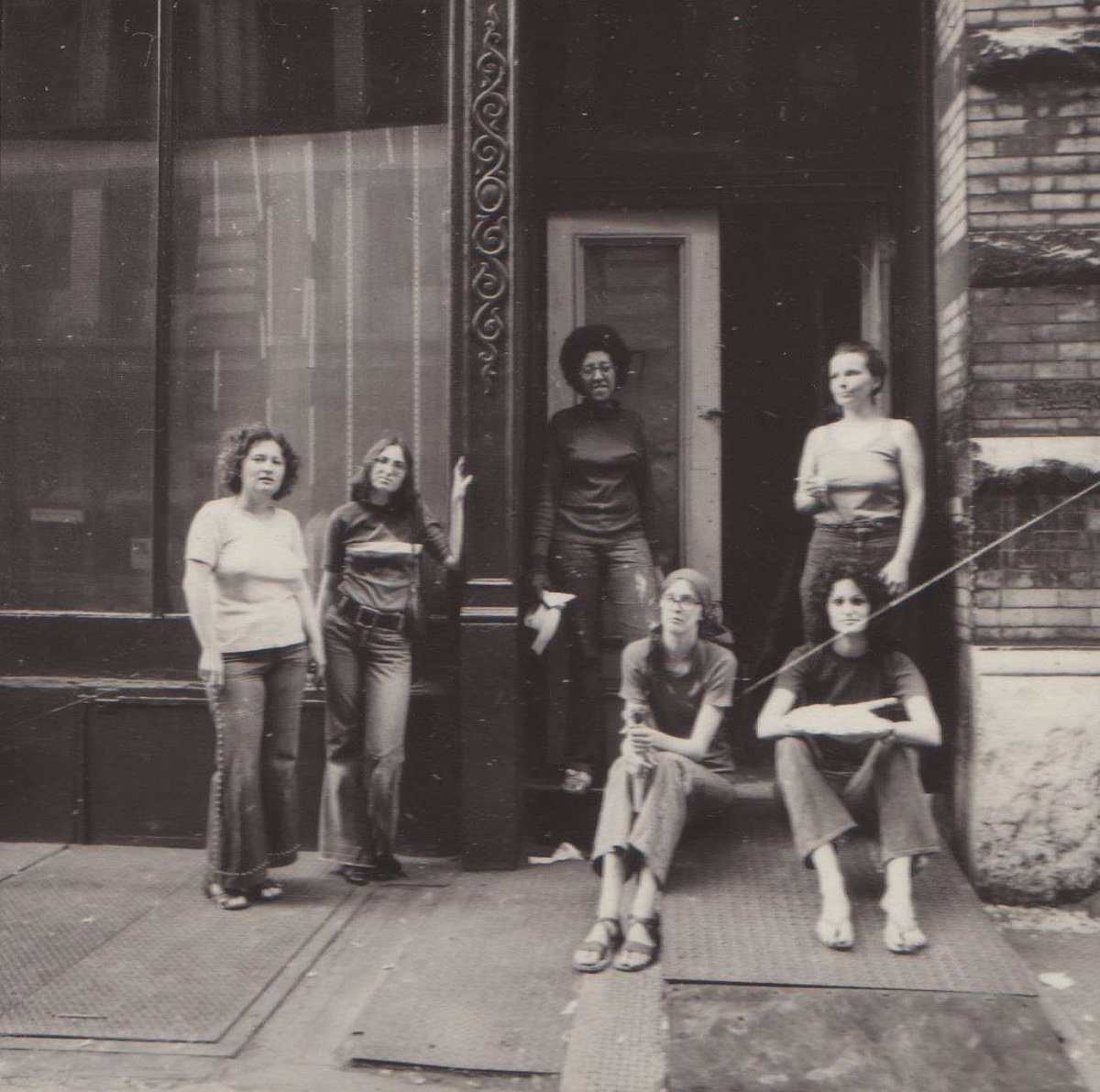 Black and white photo of A.I.R Gallery members in front of the original Crosby St. location in NYC.