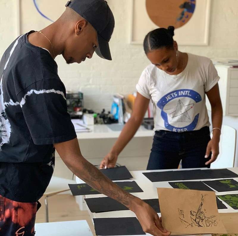 Artist Ash Arder and Assembly member Zaire select prints for an upcoming show.