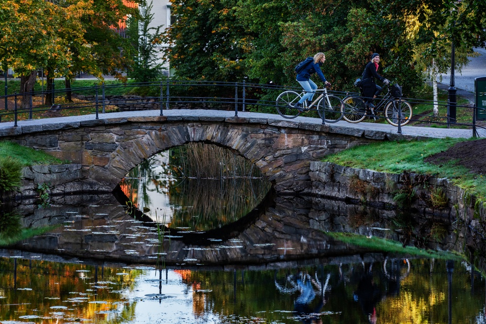 Två personer cyklar över en bro