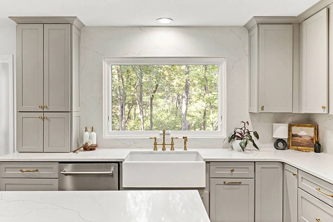 White kitchen interior with a white Infinity awning window above a kitchen sink.