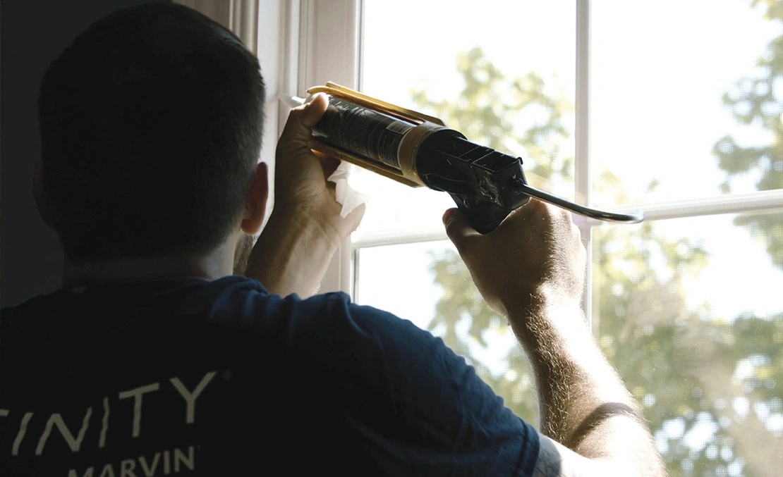 Close up of a installer calking a window