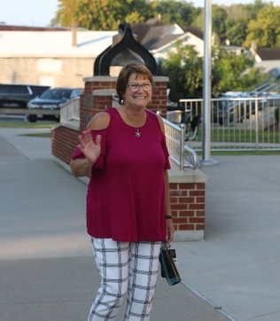 A staff member waves on the first day of school