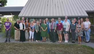 a group of new educators standing outside in front of the district office