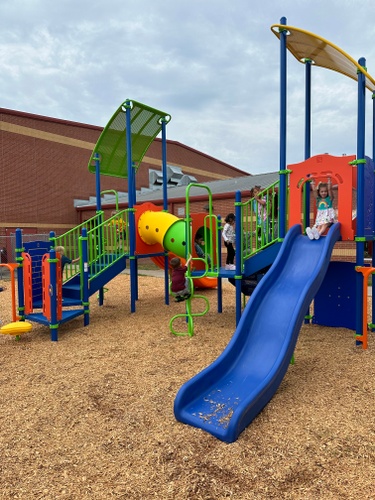 Three students on playground with slide