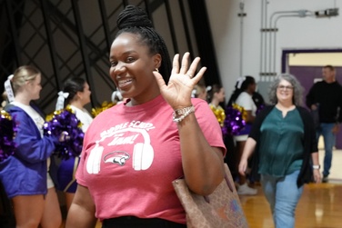 staff member in a red NWMS t-shirt waving