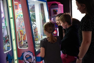 staff and family members play a game at the arcade at blue fox drive-in