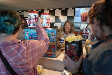 board member Sharon Jensen and staff member Mrs. Morgan-Mueller volunteer serving popcorn and beverages at the blue fox-drive in