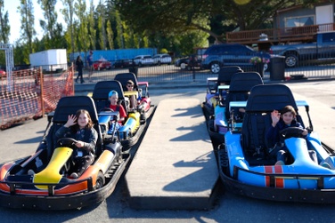 Kids of staff members sitting in two rows of go-carts at the blue fox drive-in