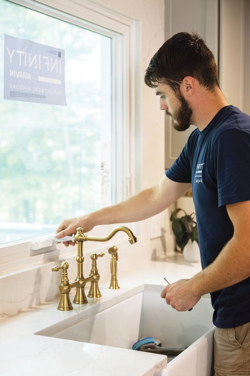 A bearded window installer checks a recently installed window.