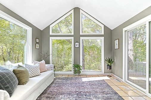 Sunroom interior with large white picture windows and special shape Infinity windows.