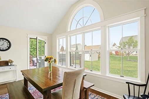 Dining room with white double hung and round top windows