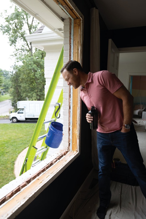 An Infinity from Marvin window installer places a single hung round top window into a frame.