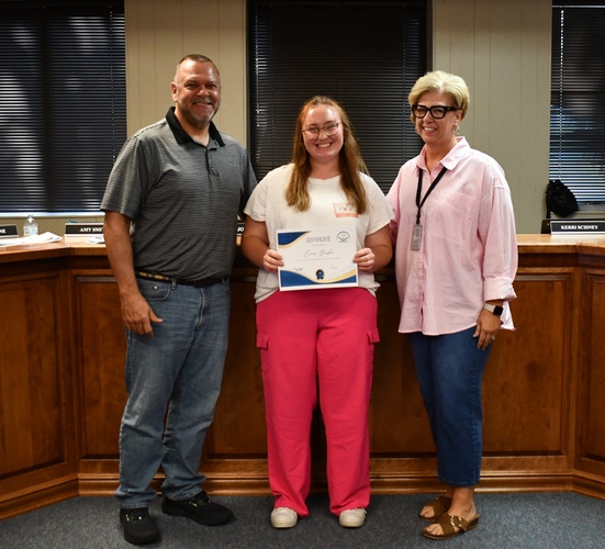 3 people pose for photo with 1 holding a certificate