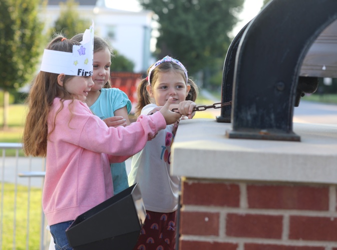 Students ring the bell to signal the start of the new school year