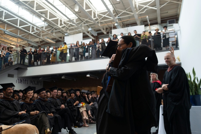 Director of Graduate Studies in Graphic Design Sheila Levrant de Bretteville hugs a graduating student as she hands him his diploma at the 2019 School of Art Commencement Ceremony.