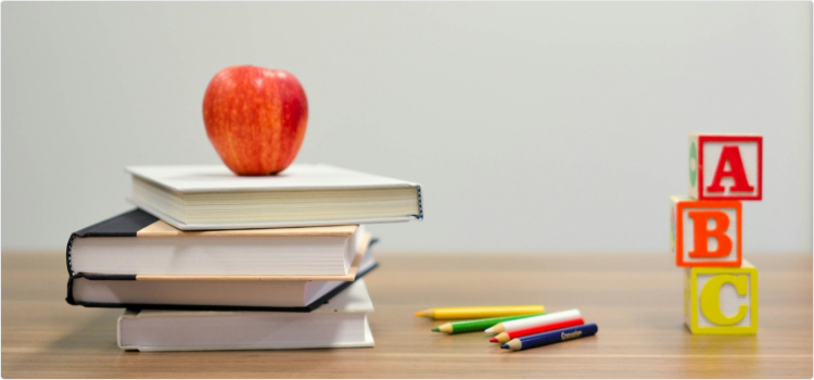 Desk with Books, pencils, blocks, and an Apple