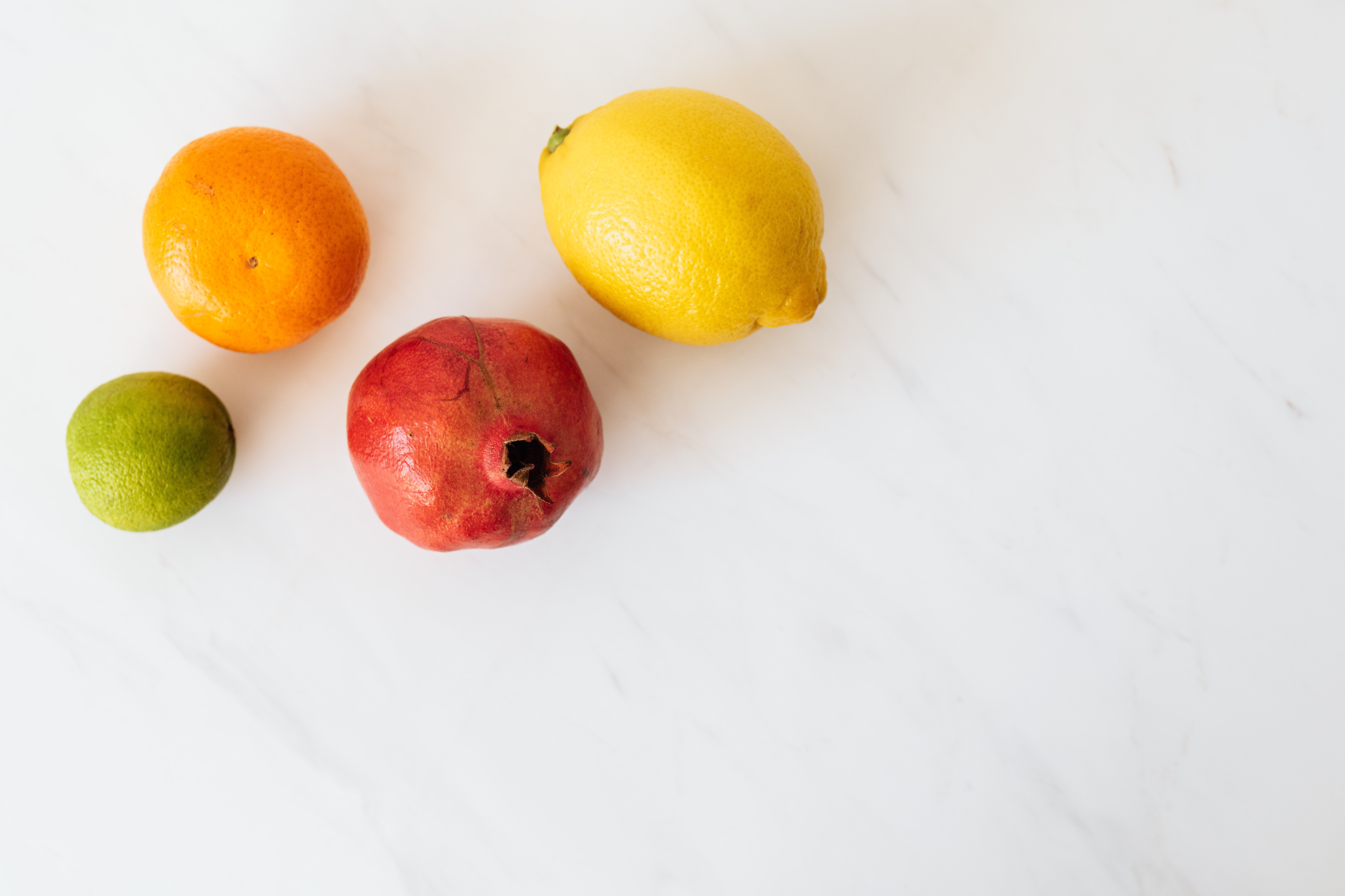 Fruits on top a a countertop in a clean kitchen.