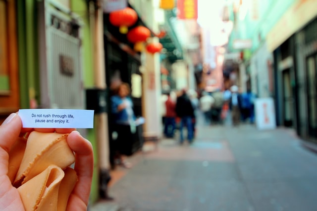 a hand holding fortune cookies and a paper