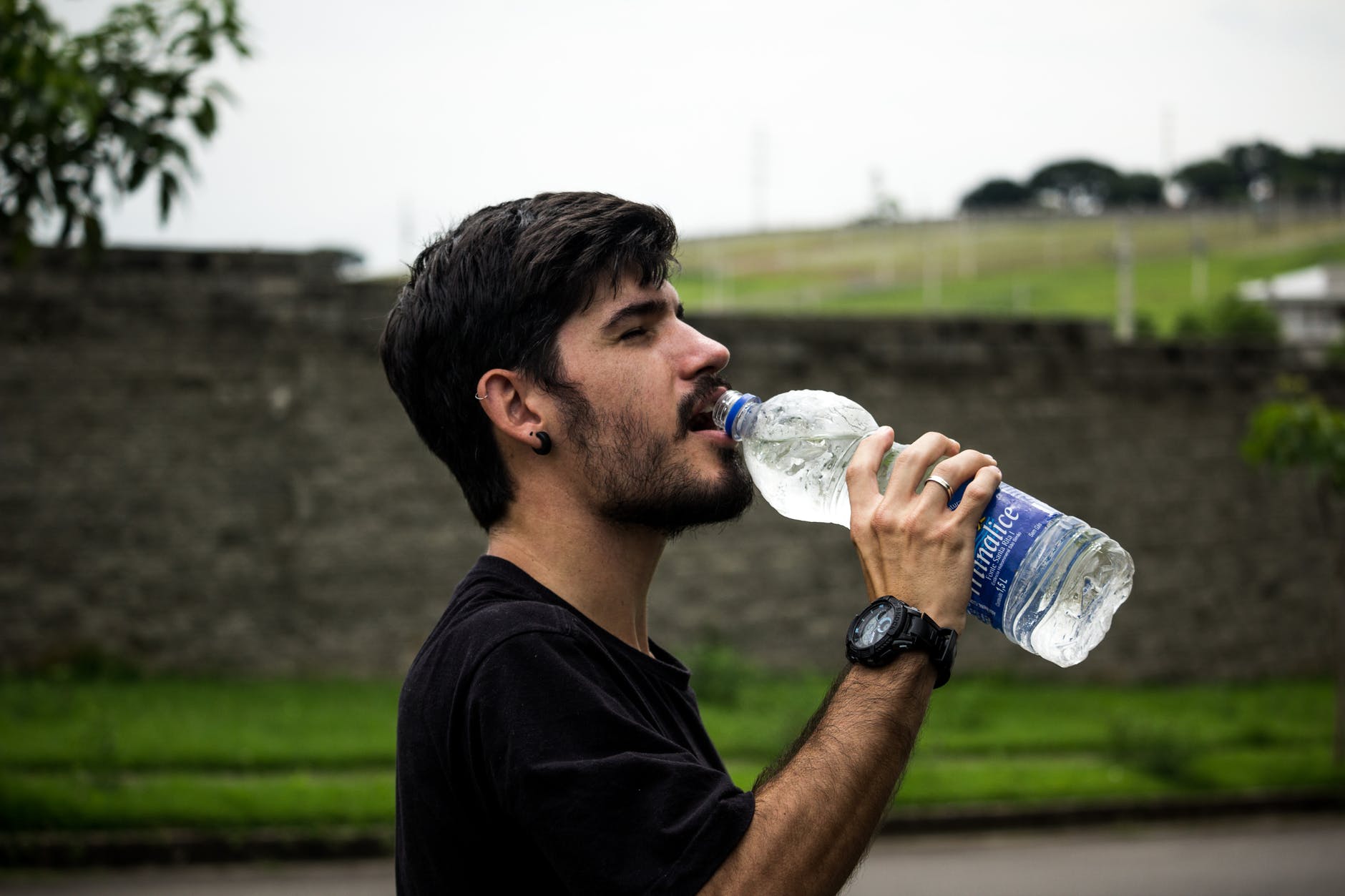 man drinking water after running