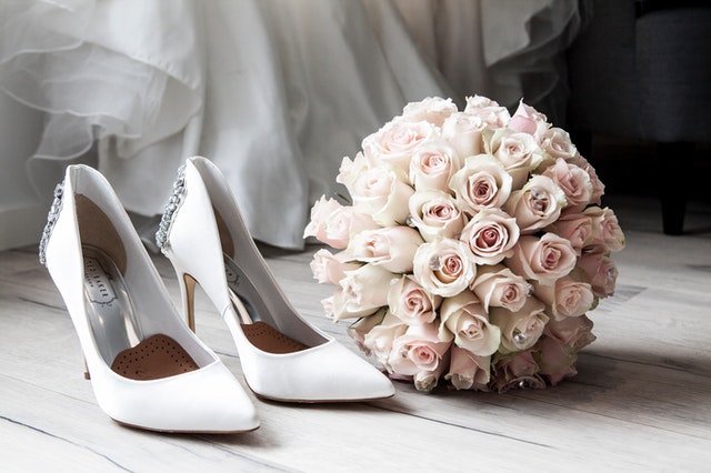 A stiletto, flower bouquet, and a glimpse of the bride's dress.