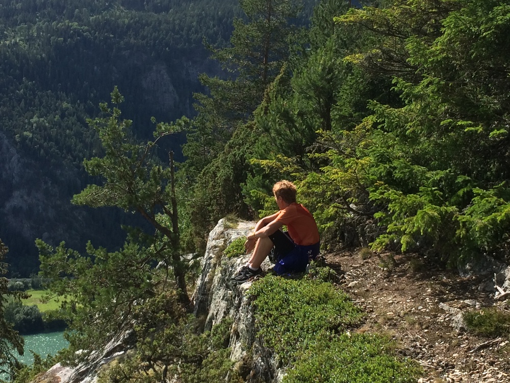 En pause for pilegrim på vei nordover Gudbrandsdalen med illgrønne Lågen i bunnen av dalen. Foto: Gudbrandsdalsmusea AS