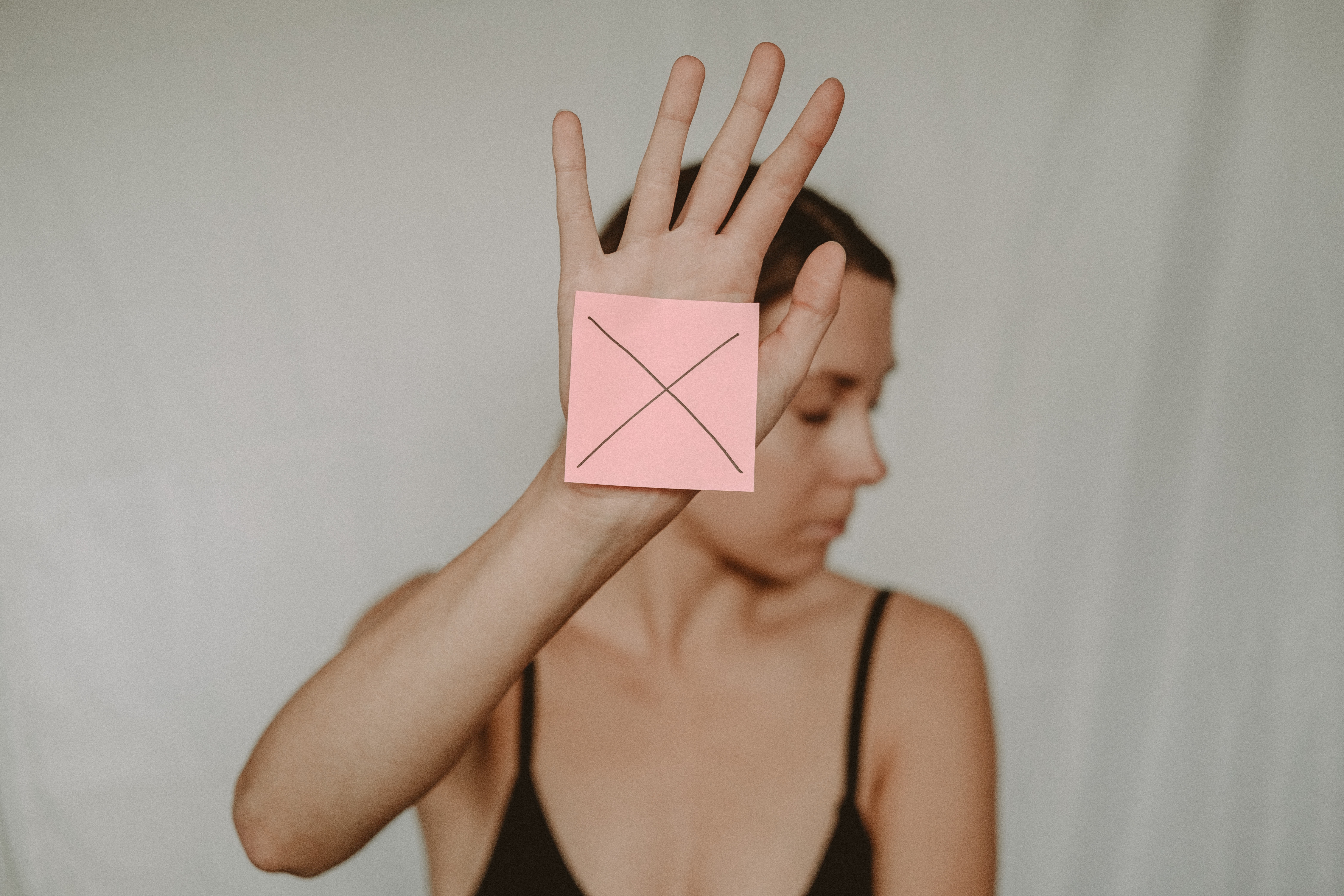 woman holding a piece of paper with an x
