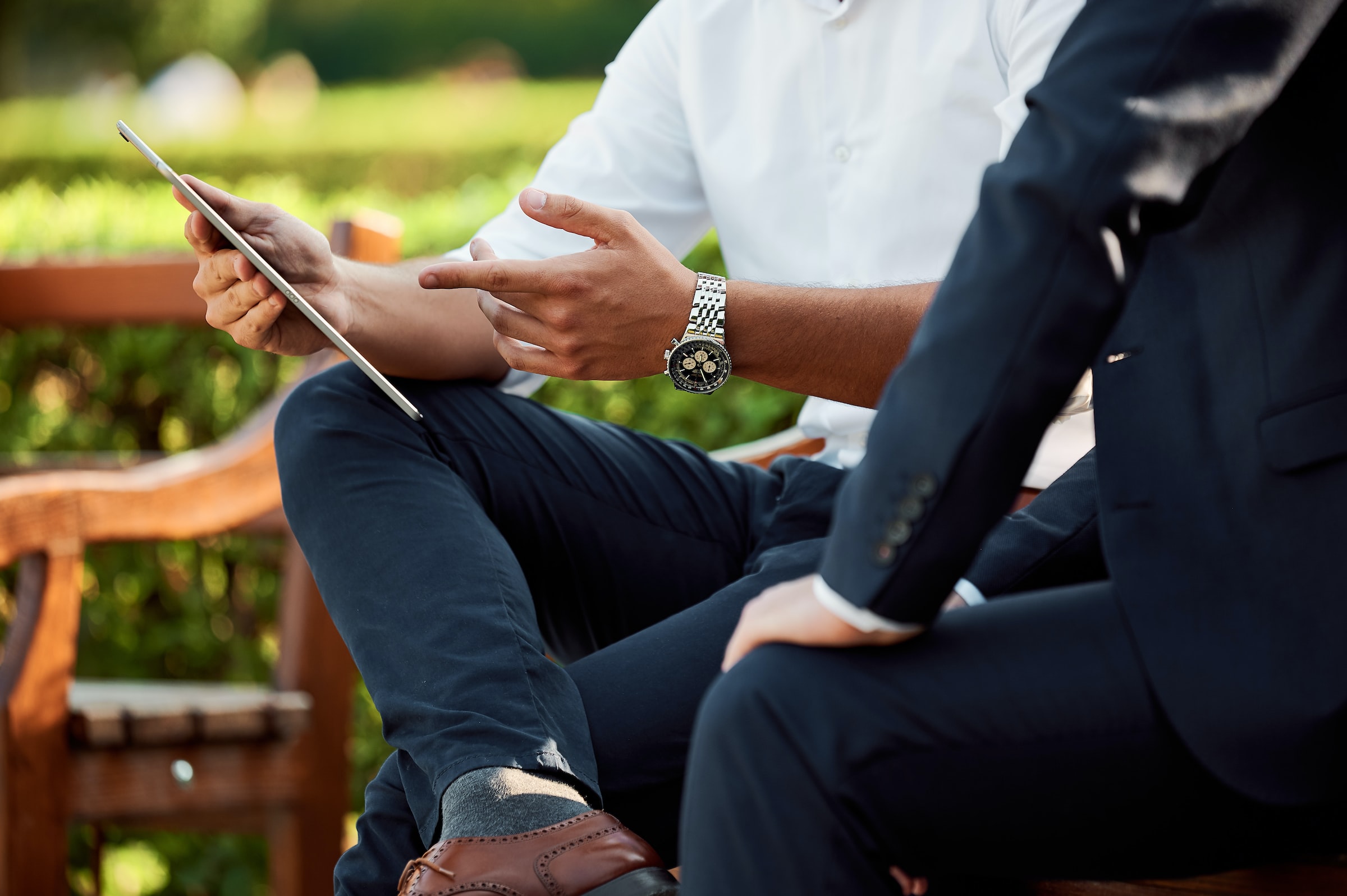 businessmen are discussing while sitting on a park bench stock image