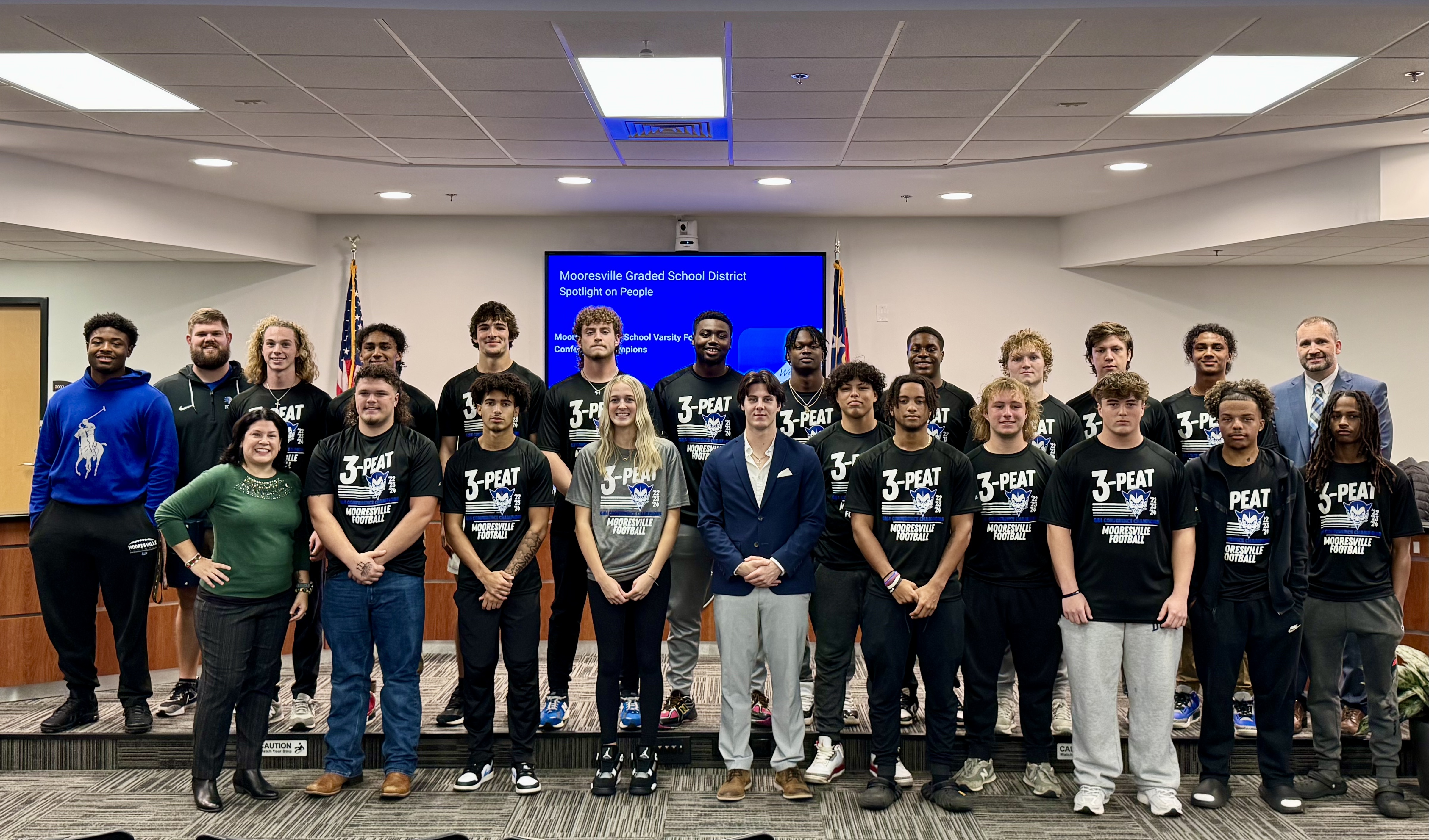 A group of football players stand posing for a photo.