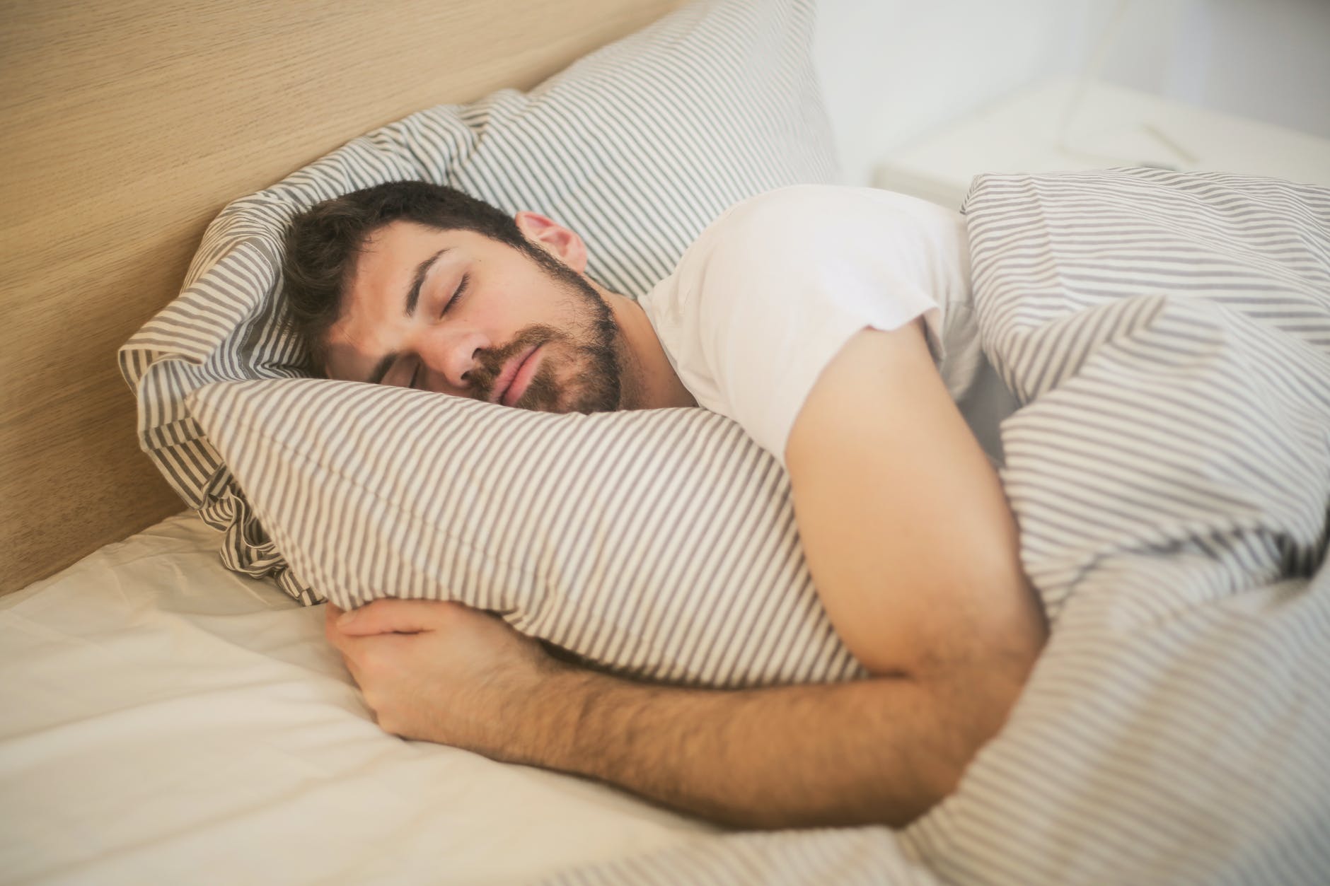 man sleeping soundly on a bed
