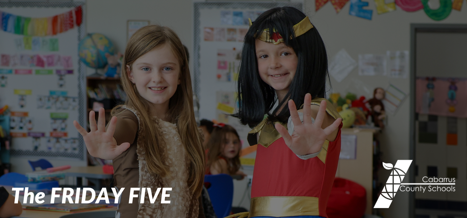 Two students holding up five fingers.