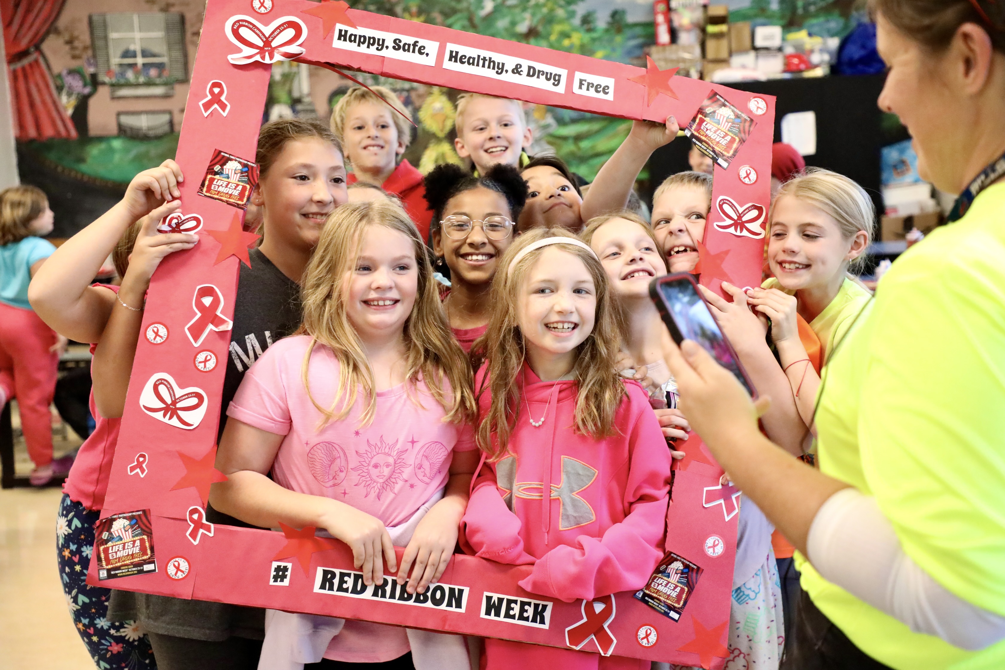 Students stand inside a picture frame for Red Ribbon Week 