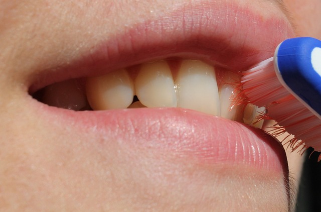 A woman brushing her teeth with her gums bleeding slightly