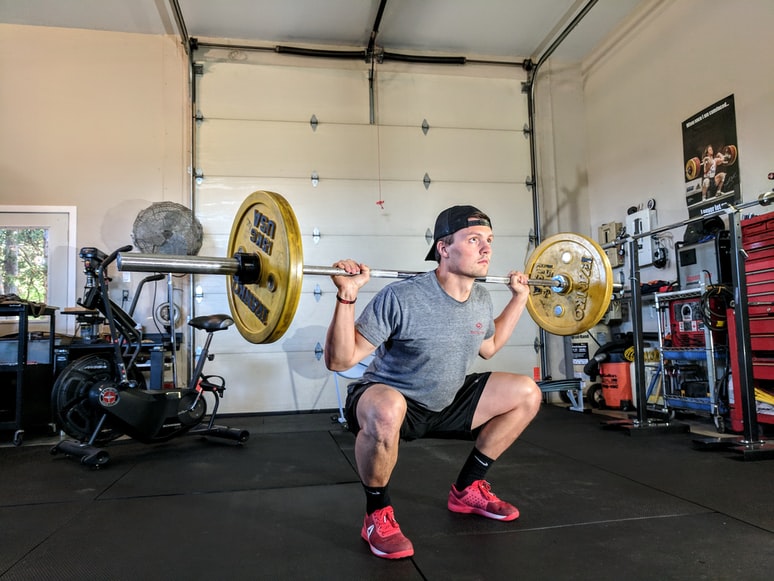 man lyfter en skivstång i gymmet