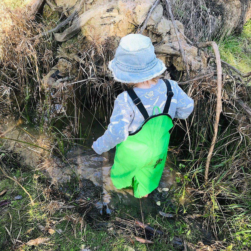 Child playing in a puddle of water