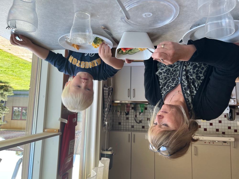Förskoleläraren Camilla Persson hjälper Milton lägga upp mat.