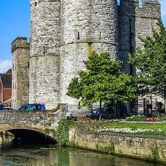 A view of a feudal castle by a canal in the city of Canterbury.