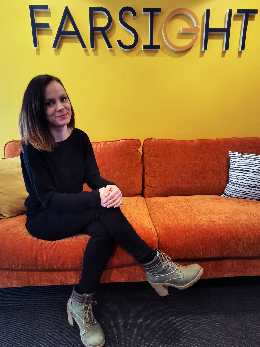 Ann-Charlotte Lund Nielsen -"Lotta" - Key Accound Manager sitter i soffan på Farsights kontor.